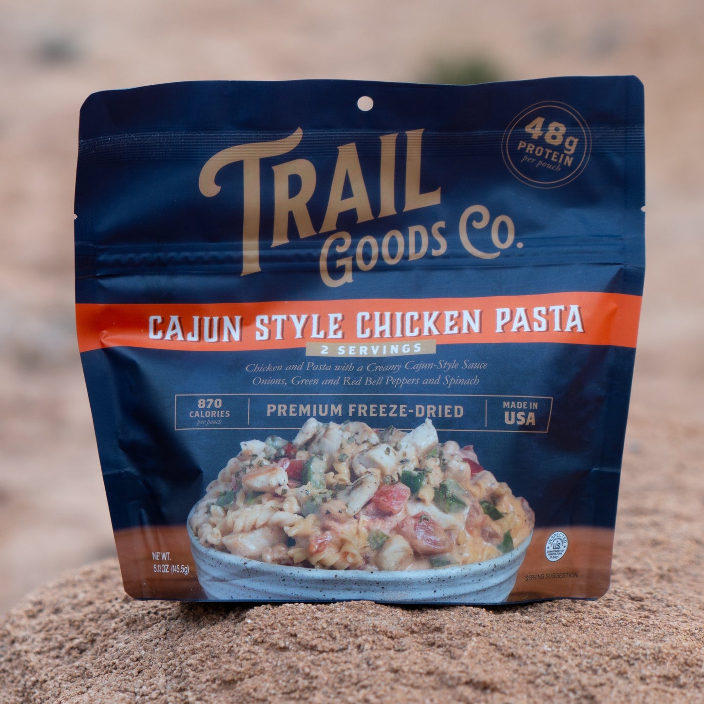 Trail Goods Co. Cajun Style Chicken Pasta package on a rocky surface
