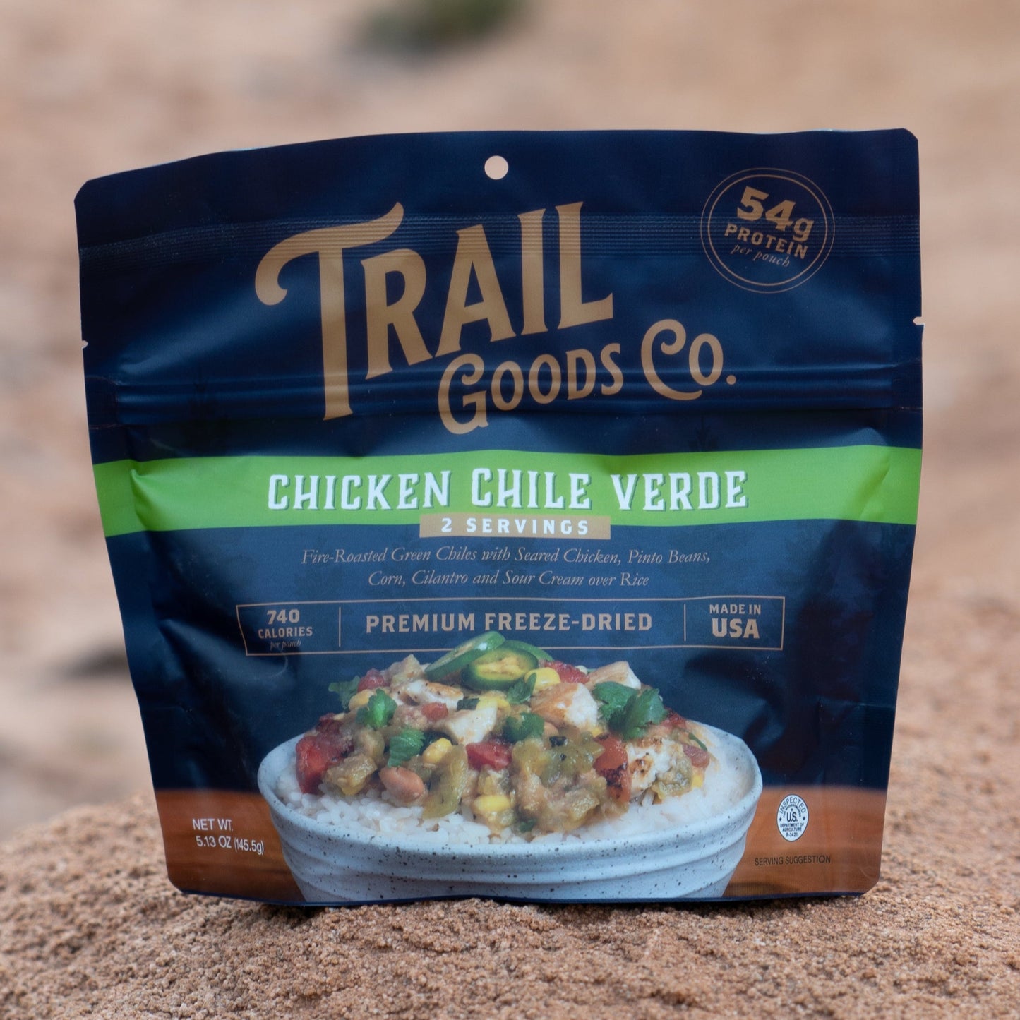 Trail Goods Co. package of Chicken Chile Verde on a rocky surface