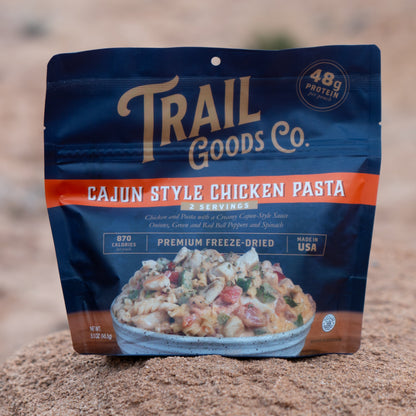 Trail Goods Co. Cajun Style Chicken Pasta package on a rocky surface